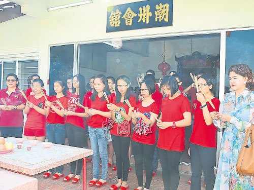 許溧師(前排左)及孫嬡瑾(右),帶領(lǐng)少男少女祭拜福德正神。(馬來西亞《中國報》)