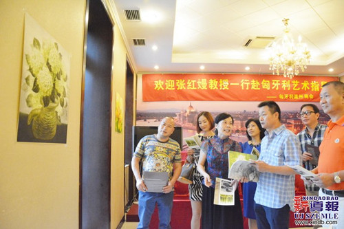 張紅嫚(左三)在交流會上為匈牙利僑胞們講解她的作品。(匈牙利《新導(dǎo)報(bào)》/金曉曉