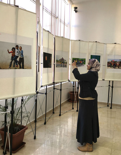 中國(guó)僑網(wǎng)一位摩洛哥婦女仔細(xì)觀看攝影作品