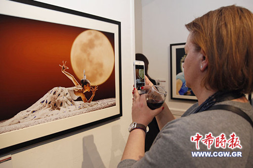 中國(guó)僑網(wǎng)觀眾在觀看攝影作品。(希臘《中希時(shí)報(bào)》/王洪普 攝)