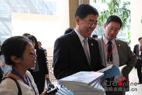 中國僑網(wǎng)國家旅游局副局長杜江認真翻閱《帶你游北京》。(洪荃詮 攝)