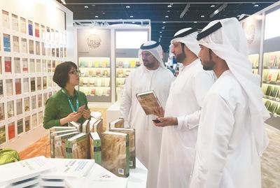 中國僑網(wǎng)阿聯(lián)酋讀者在中國主賓國展區(qū)內(nèi)與中國出版商交流。(本報(bào)記者 王云松 攝)