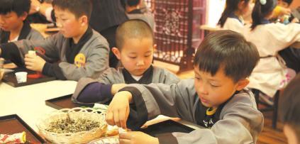 中國僑網(wǎng)聚隆光明中醫(yī)藥傳承教育中心的“小中醫(yī)”正在稱量中藥。