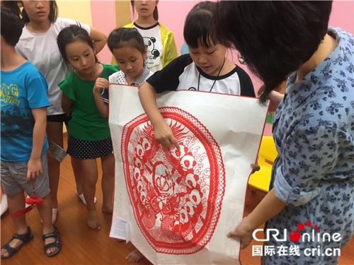 中國僑網(wǎng)熊貓小記者向新加坡北京語文學校老師贈送中國傳統(tǒng)剪紙