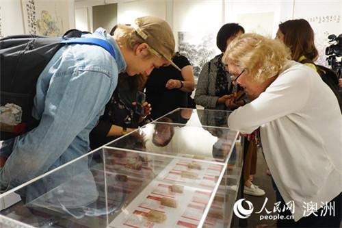 中國(guó)僑網(wǎng)當(dāng)?shù)孛癖娦蕾p展出的篆刻作品(攝影 羅小紅)