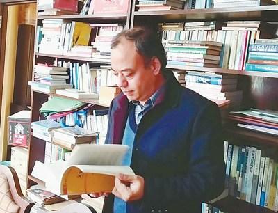 中國僑網塔姆在書房查閱有關中國的資料。 苑基榮攝