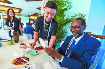 中國(guó)僑網(wǎng)《蘇丹視野報(bào)》記者阿布達(dá)拉正在體驗(yàn)京劇臉譜上色。本報(bào)記者 鄧偉攝