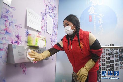 中國僑網(wǎng)西南大學(xué)尼日利亞籍留學(xué)生志愿者方雯對電梯按鈕進(jìn)行衛(wèi)生消毒(新華網(wǎng)/王全超 攝)