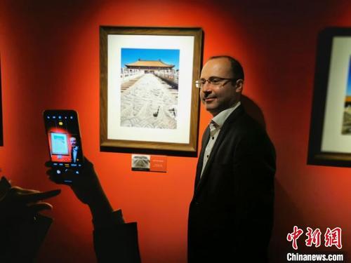 中國(guó)僑網(wǎng) 一位駐華外交官興奮地在自己作品前合影 應(yīng)妮 攝